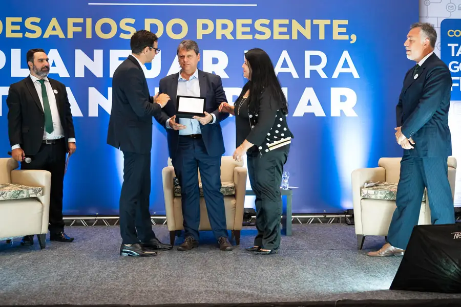 Entrega de homenagem no palco do workshop